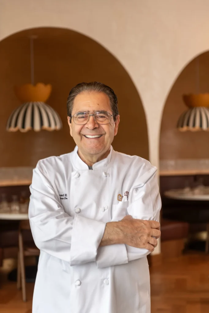 Sous Chef Jamil Eido, Chef Rachid's father, smiling with arms crossed in front of arched alcoves