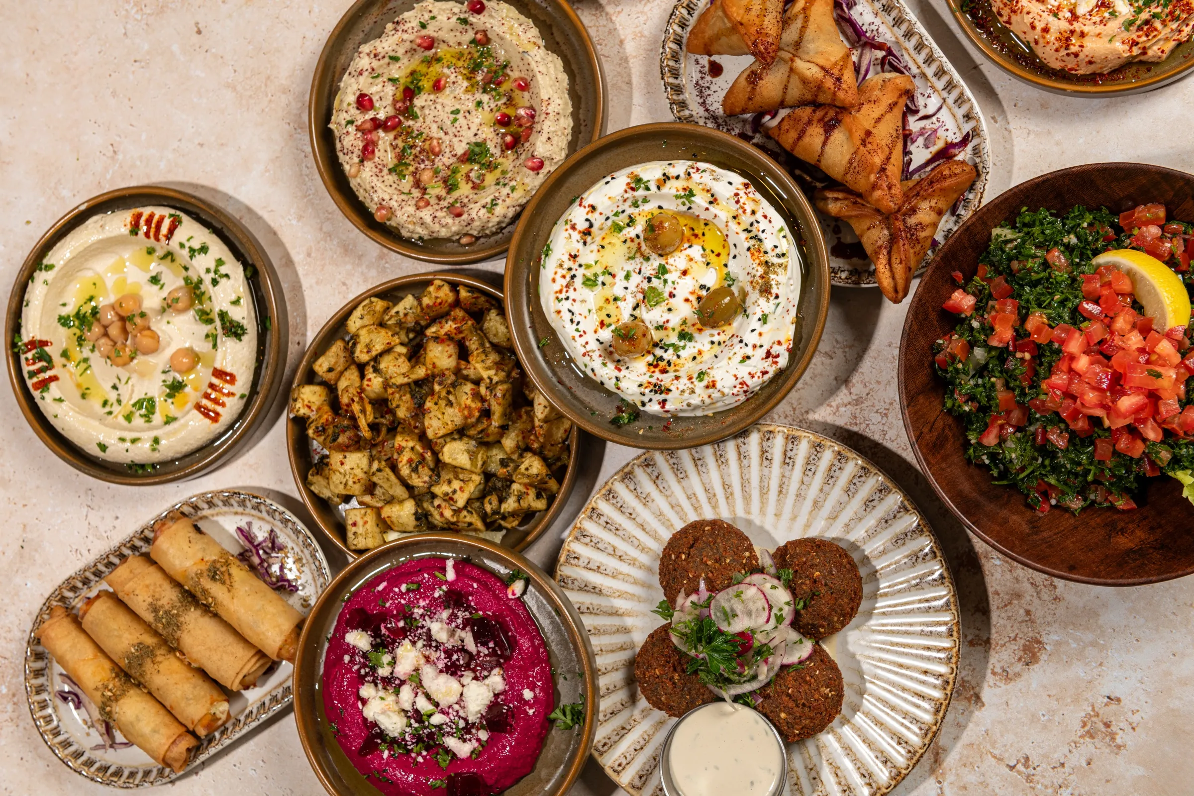 Hummus, baba ghanoush, labneh, beet dip with feta, tabbouleh, falafel, spiced potatoes, cheese rolls and pastries